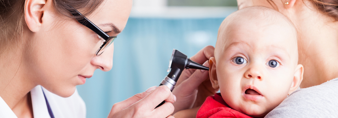 Ärztin untersucht Ohr eines Babys
